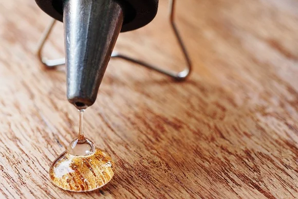 Klebepistole tropft auf Holz